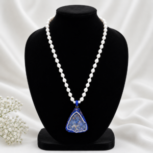 White beaded necklace with blue triangular pendant